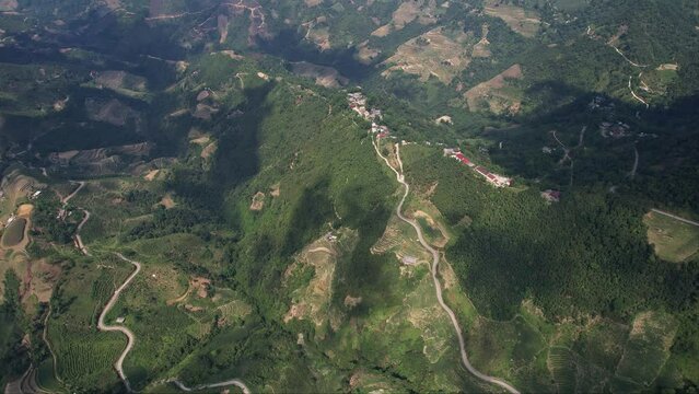 an aerial view of a mountain range with a winding road going through it 4K view Ha Giang Loop Vietnam Asia