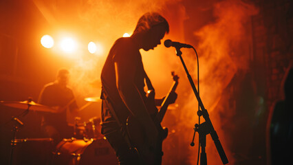 A guitarist performing on stage with dramatic lighting and smoke, creating an intense atmosphere.
