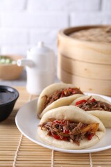 Plate with delicious gua bao (pork belly buns) on table, closeup