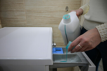 a woman pours detergent into the washing machine