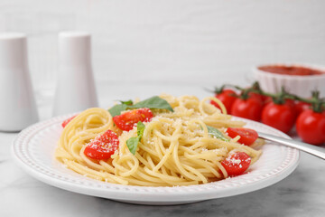 Tasty pasta with tomato, cheese and fork on white marble table, closeup