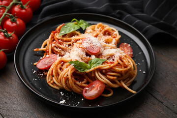 Tasty pasta with tomato sauce, cheese and basil on wooden table