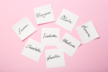 Paper stickers with different names on pink background, flat lay. Choosing baby's name