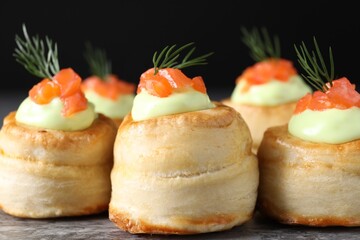Delicious puff pastry with avocado cream, salmon and dill on grey table, closeup