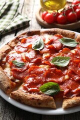 Tasty pepperoni pizza with basil on wooden table