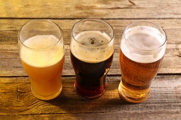 Glasses with different types of beer on wooden table © New Africa