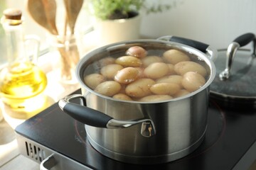 Boiling potatoes in pot on stove in kitchen