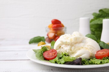 Delicious fresh burrata salad on white wooden table, closeup. Space for text