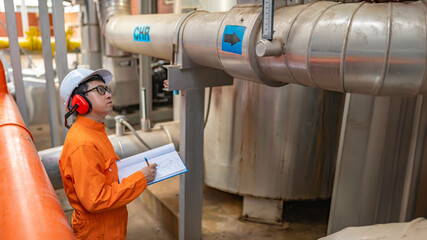 Maintenance technician at a heating plant,Petrochemical workers supervise the operation of gas and oil pipelines in the factory,Engineers put hearing protector At room with many pipes