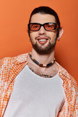 Caucasian man with beard and glasses wearing a necklace.