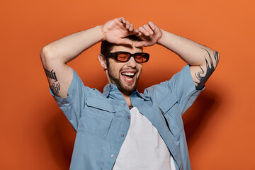 Handsome Caucasian man in trendy blue shirt and sunglasses.