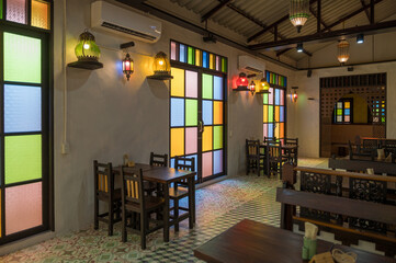 Interior view of a cozy restaurant featuring stained glass windows and warm ambient lighting.