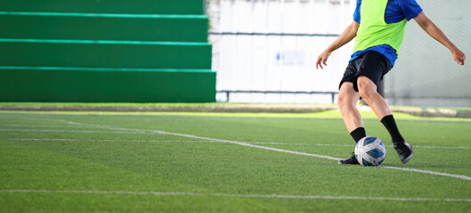 Soccer players in action during a game on a grass field, focusing on their legs and the ball.
