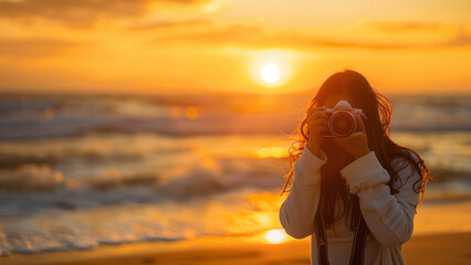 A photographer captures the breathtaking beauty of a sunset on the beach, with waves crashing and the sky painted in golden hues, creating a serene and picturesque moment.
