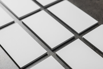 Blank business cards on grey textured table, closeup. Mockup for design