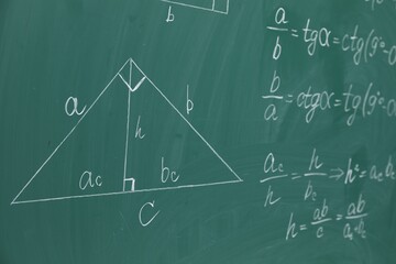 Many different math formulas written on chalkboard