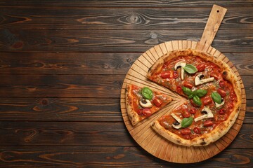 Tasty pizza with basil, mushrooms, chili pepper and tomato on wooden table, top view. Space for text