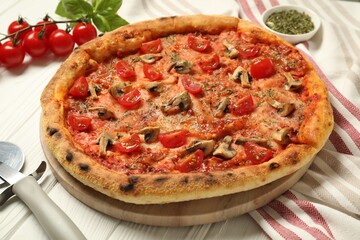 Tasty pizza with mushrooms, herbs and tomato on white wooden table, closeup