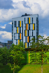 Fototapeta premium City view on a sunny day. Modern building and houses against the blue sky.