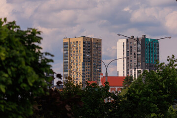 Obraz premium Cityscape on a summer day, modern buildings and houses against the blue sky 