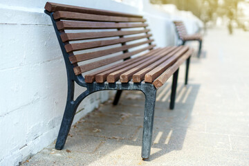 A line of benches aligned by a whitewashed brick wall, offering a tranquil urban resting spot