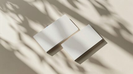 Close up of white business cards mock up, template for design copy space. With warm sunny light and shadows overlay.3