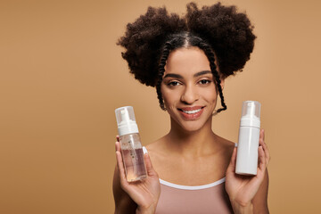 A young African American woman with a radiant smile holds two bottles of face wash, highlighting her natural beauty and confidence.