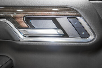 Close up shot of luxurious car interior door trim and door latch.