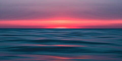 Obraz premium Serene ocean sunset. Blurred horizon with pink and blue hues.