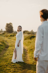 newlywed couple in love in a field in nature at sunset in summer