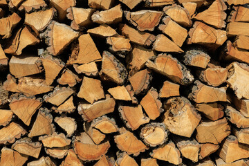 A pile of wood logs with a lot of bark on them