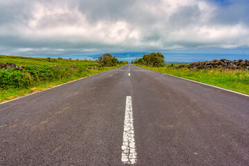 Tarmac road with the beautiful landscape surrounding the island of Pico in the Azores archipelago.