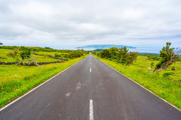 Tarmac road with the beautiful landscape surrounding the island of Pico in the Azores archipelago.