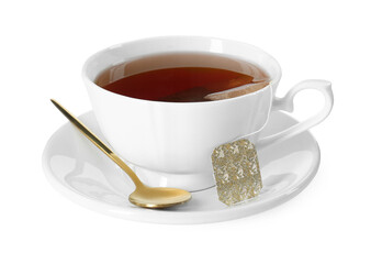 Brewing aromatic tea. Cup with teabag and golden spoon isolated on white
