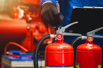 Engineer check fire extinguisher tank in the fire control room for safety in factory or industry.