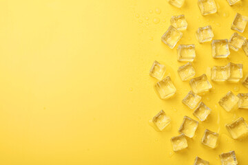 Crystal clear ice cubes on yellow background, flat lay. Space for text