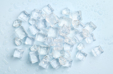 Crystal clear ice cubes on light blue background, flat lay