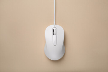 One wired mouse on beige background, top view