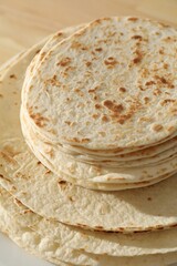 Many tasty homemade tortillas on table, closeup