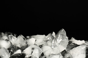 Pile of crushed ice on black background, space for text