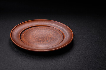 Empty ceramic round plate on dark textured concrete background
