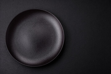 Empty ceramic round plate on dark textured concrete background