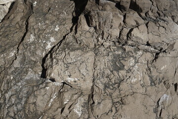 Rocks on the coast in Italy. Sorrento Peninsula. Mediterranean Sea. Texture of a steep stone mountain.