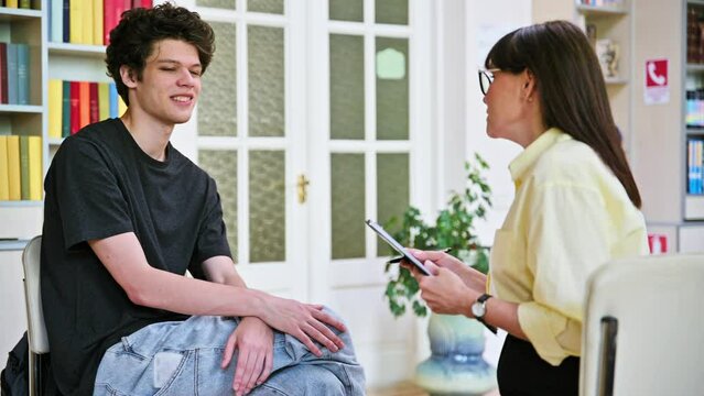 Psychologist working with young male college student in educational office