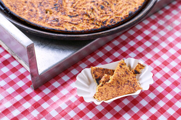 Socca, just coming out of the oven, in Nice, the French Riviera. a type of thin, Socca is a specialty of southeastern French cuisine. a pancake made from chickpea flour.