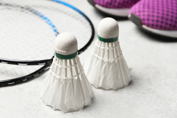 Feather badminton shuttlecocks and rackets on gray background, closeup