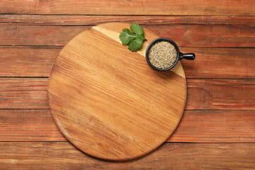 Cutting board, cumin and parsley on wooden table, top view. Space for text