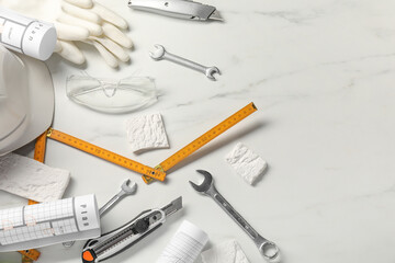 Flat lay composition with different construction tools on white marble background, space for text