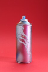 One can of bright spray paint on red background
