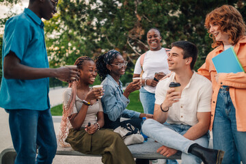 Interracial group of college students chatting on coffee break at campus